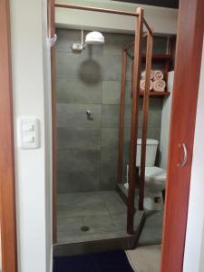 a bathroom with a shower with a toilet in it at Hospedaje Wiruyana in Cotacachi