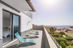 una fila di sedie blu sul balcone di un edificio di Villa Old Town by Villa Plus a Funchal