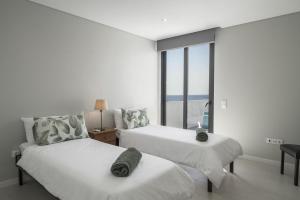 una camera da letto con due letti e una grande finestra di Villa Old Town by Villa Plus a Funchal Altre 17 foto