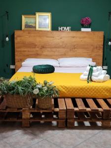 a bed in a bedroom with two plants on a bench at Casa Twins in Sassari