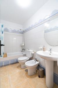 a bathroom with two toilets and a sink and a tub at apartamento Sunrise Apolo in Torrevieja +39 photos