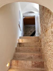 a staircase in a house with a stone wall at Yi artistry 1-bedroom medieval holiday house in Kalamoti