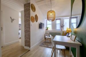 a dining room with a table and chairs and a room with at HONORÊ SUITE FERRANDIERE in Lyon