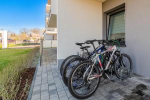 dos bicicletas están estacionadas al lado de un edificio en Apartament Rowerowo przez Mierzeję, rowery gratis, en Sztutowo