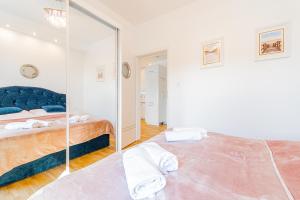 a bedroom with a blue bed and a mirror at Apartament Rowerowo przez Mierzeję, rowery gratis in Sztutowo