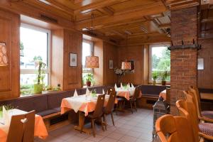 a dining room with tables and chairs and windows at Hotel Deutscher Hof in Babenhausen