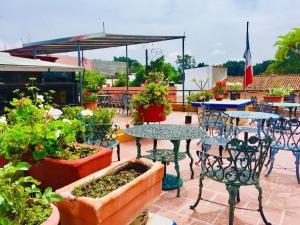 un patio con mesas, sillas y macetas en Hotel Cazomalli Oaxaca en Oaxaca de Juárez