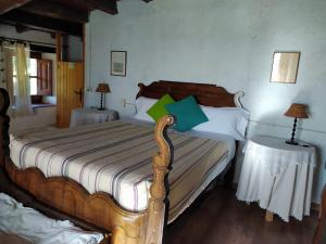 a bedroom with a wooden bed with two tables at El Buxaus de la Muntanya in Arbúcies