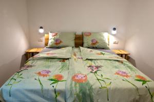 a bedroom with a bed with a floral bedspread at Apartmaji Tanto Malovše in Črniče