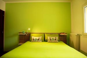 ein grünes Schlafzimmer mit einem Bett mit einer grünen Wand in der Unterkunft Sweet Home in LʼAquila
