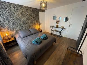 a bedroom with a bed with two towels on it at Logement avec terrasse et parking in Concarneau