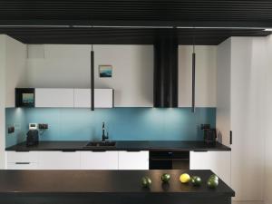 a kitchen with white cabinets and a black counter top at Szprot Gdynia - YACHT PARK in Gdynia