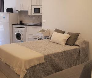 uma cama num pequeno quarto com máquina de lavar e secar roupa em Estudio Rocío em Benalmádena