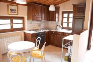 a kitchen with wooden cabinets and a table and a table and chairs at Beautiful Tranquil Villa in Tuscany in Sarteano