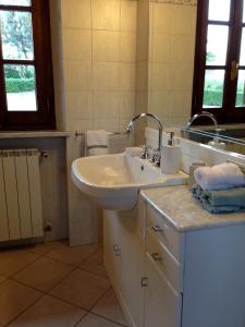 サルテアーノにあるBeautiful Tranquil Villa in Tuscanyの白いバスルーム(シンク、鏡付)