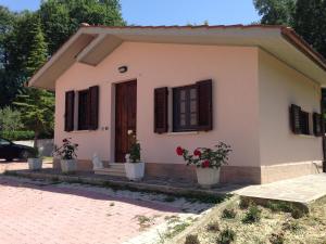 a small house with two potted plants in front of it at Beautiful Tranquil Villa in Tuscany in Sarteano