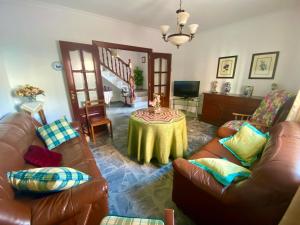 Una sala de estar con dos sofás de cuero y una mesa. en Casa Nati, en Alfarnate