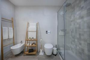 a bathroom with a tub and a toilet and a shower at Sunset Apartment in Sagres +16 photos