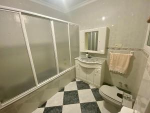 Un baño blanco con inodoro y lavabo. en Casa Nati, en Alfarnate