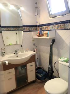 ein Badezimmer mit einem Waschbecken, einem WC und einem Spiegel in der Unterkunft Beachfront and Peaceful Apartment in Mareny Barraquetas