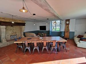 una sala de estar con una gran mesa de madera y sillas en Gîte - Le Moussat, en Lagraulet-du-Gers