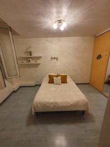 ein Schlafzimmer mit einem großen Bett mit Kissen darauf in der Unterkunft Appartement ardeche vallée de l'ouvèze SANS extérieur mais à proximité de parcs in Flaviac