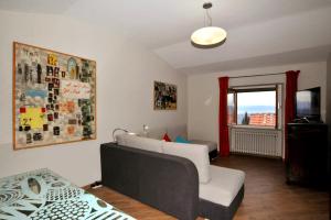 een woonkamer met een bank en een raam bij Atelier di Denise in Panicale