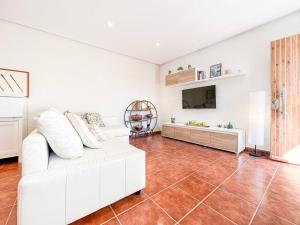 a living room with a white couch and a tv at Apartament 'Es Botànic' in Blanes