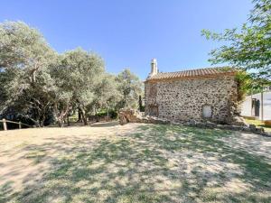 an old stone house with trees in front of it at Apartament 'Es Botànic' in Blanes