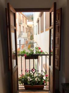 una puerta abierta con un balcón con flores en Casa Esperanza en Lanjarón
