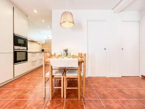 a kitchen with a table and some white cabinets at Apartament 'Es Botànic' in Blanes
