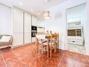 a dining room with a table and a bunk bed at Apartament 'Es Botànic' in Blanes