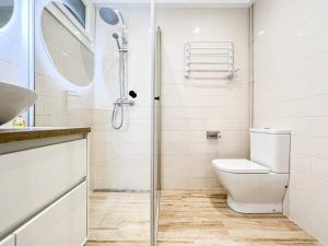 a white bathroom with a shower and a toilet at Apartament 'Es Botànic' in Blanes +37 photos