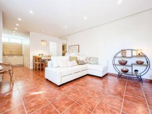 a living room with a white couch and a table at Apartament 'Es Botànic' in Blanes