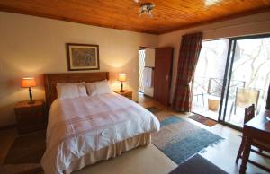 ein Schlafzimmer mit einem großen Bett und einem großen Fenster in der Unterkunft Kruger River Holiday Home in Marloth Park + 58 Fotos