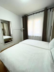 1 dormitorio con 1 cama blanca grande y espejo en Apartment Branka Kustura, en Hvar