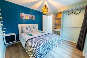 - une chambre avec un lit et un mur bleu dans l'établissement Séjour à Melun La Maisonnette Melunaise, à Melun