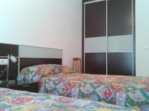 a hotel room with two beds and a mirror at Apartamento Rural Arluzepe in Echarri-Aranaz