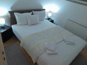 una camera con un letto bianco con due cuscini di Apartment Vojinovic a Arandjelovac