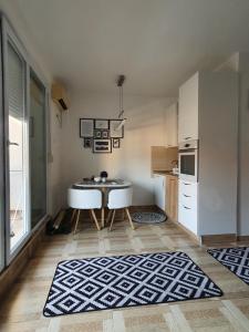 uma pequena cozinha com uma mesa e uma cozinha com uma cozinha em Apartman Bečići - Budva em Budva