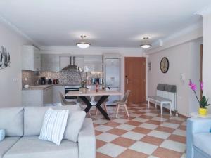 ein Wohnzimmer und eine Küche mit einem Sofa und einem Tisch in der Unterkunft Blue Lagoon Luxury Apartment G2 in Argostoli