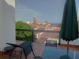 een balkon met een tafel en stoelen en een parasol bij Can Llavi in Canet de Mar