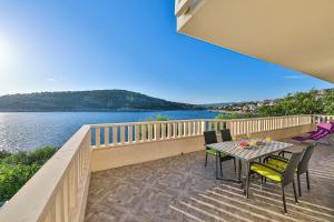 a table and chairs on a balcony with a view of the water at Rajcic Apartments in Rogoznica