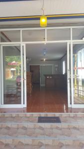 a living room with sliding glass doors and a table at Phatra Hostel in Thong Sala