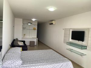 Un dormitorio con una cama y un televisor de pantalla plana. en Flat a margem do açude velho, en Campina Grande