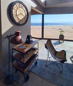 a room with a clock and a desk and a chair at Dolphin Beach Villa at 138 Oystercatcher, Swakopmund in Rand Rifles