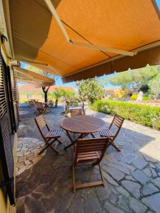 einen Tisch und Stühle unter einem Sonnenschirm auf einer Terrasse in der Unterkunft Agriturismo Monte Istulargiu in Valledoria