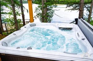 a jacuzzi tub in a backyard with trees at Sun Apartamenty Sominy in Sominy