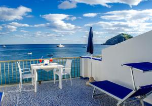 a balcony with a table and chairs and the ocean at Hotel Regina del Mare in Ischia
