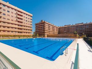 a large swimming pool in front of two tall buildings at Aires de Toledo-Parque Warner y Madrid en familia in Toledo